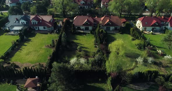 Drone point of view of red roofs housing estate in the suburbs surrounded by forest.