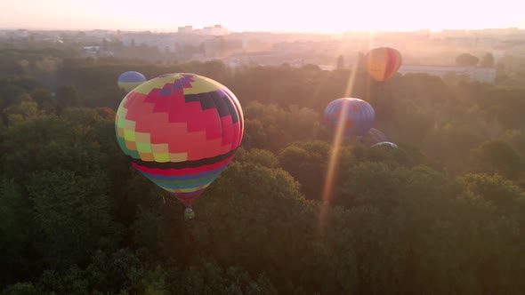 Aerial Drone View of Colorful Hot Air Balloon Flying Over Green Park and River in Small European