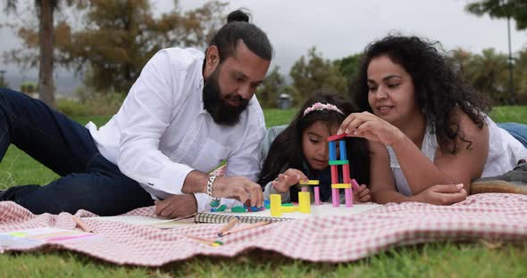 Indian parents having fun at city park playing with wood toys with their children