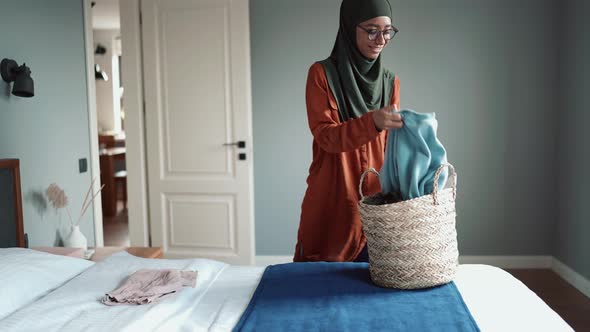 Positive Muslim woman wearing eyeglasses stacking things