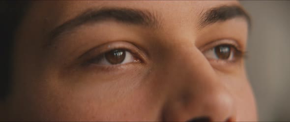 Closeup of the eyes of a young man daydreaming