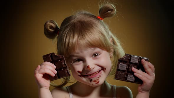 Satisfied Teen Child Kid Girl Holding Chocolate Bars Making Faces Smiling Showing Tongue