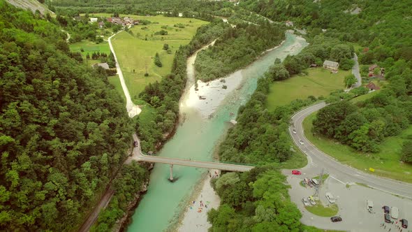 Aerial view of a group of people doing rafting going under a bridge.