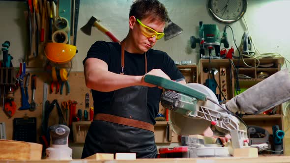 Young Carpenter Sawing Board with Circular Saw