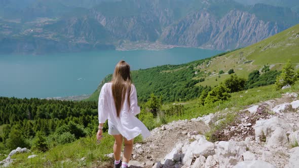 Tourist Girl Walks on the Rocky Mountain with Beautiful Landscape