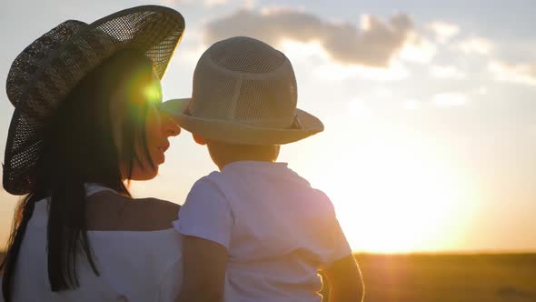 Happy Mother Playing with Little Son at Sunset. Young Caucasian Mom and Baby Boy Having Fun Outdoor