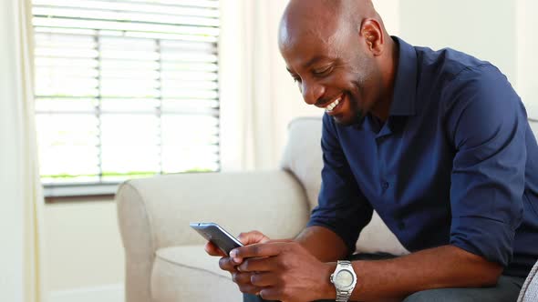 Man using mobile phone in living room 4k