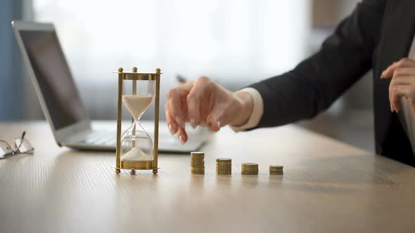 Lady Adding Coin to Stack on Office Desk, Bank Earning Interests, Repaying Loan