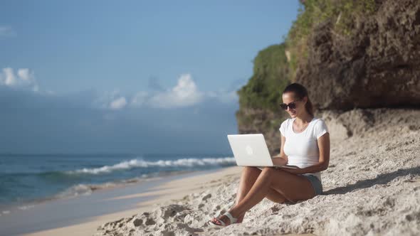 Happy Young Woman in Sunglasses Talking on Video Communication on Laptop