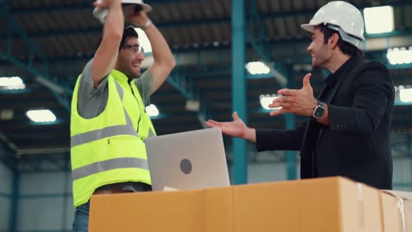 Two Factory Worker Celebrate Success Together in the Factory