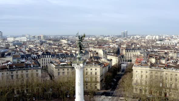 Angel of liberty Girondins monument in Bordeaux, France with city panoramic, Aerial circling shot