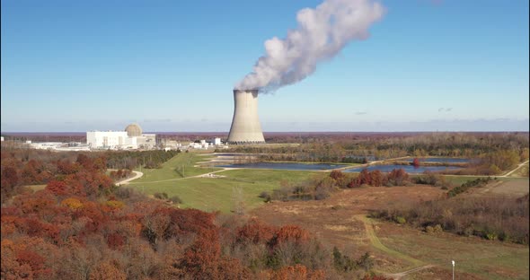 Nuclear power plant with steam going out. Drone video pulling out.