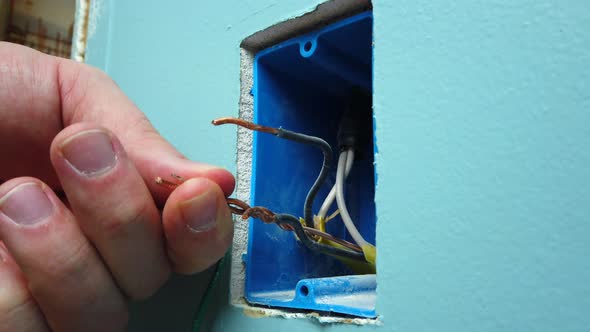 Connecting wires and twisting on a few wire nuts for a light switch install.