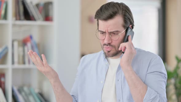 Portrait of Aggressive Man in Glasses Angry on Smartphone