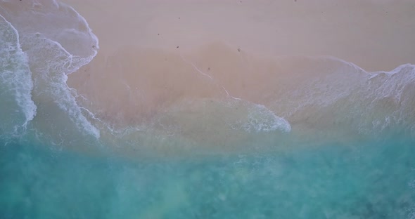 Beautiful birds eye copy space shot of a white paradise beach and blue sea background in vibrant 4K