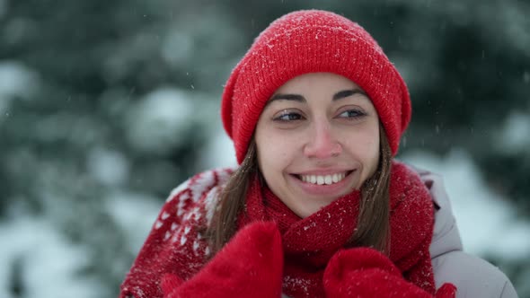 Super Close Up Happy Smiling Woman in Knitted Hat and Scarf in Snowy Winter Park at Frizzy Day with