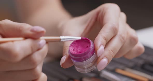 Professional Make Up Artist Applying Liquid Pink Lipstick on Hand Skin, Close Up