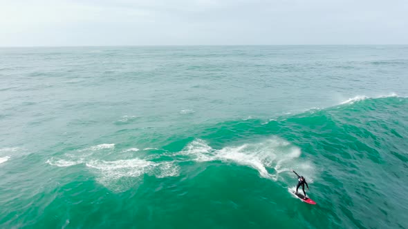 Man Surfs Fantastic Ocean Wave Following Scooter Aerial View