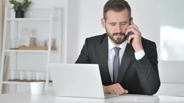 Businessman Talking on Phone Negotiating with Customer