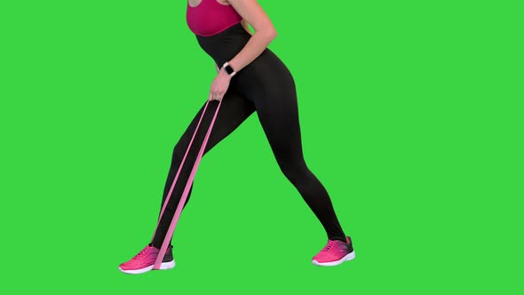 Young Woman Doing Exercise for Her Back with Elastic Band on a Green Screen Chroma Key