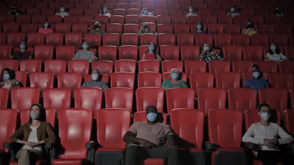 Diverse Masked Viewers Watching Movie in Cinema