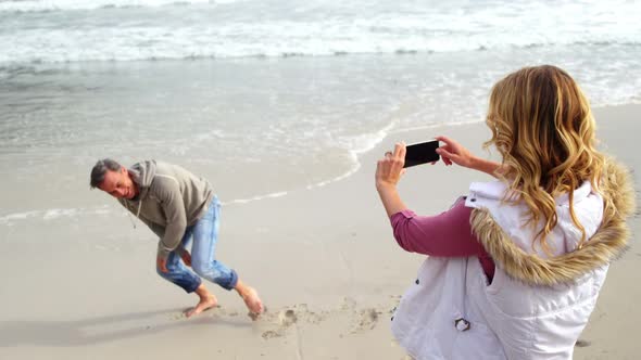 Woman taking photo of man