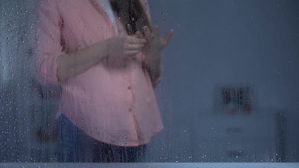 Pregnant Lady Taking Off Engagement Ring From Finger on Rainy Day, Single Mother