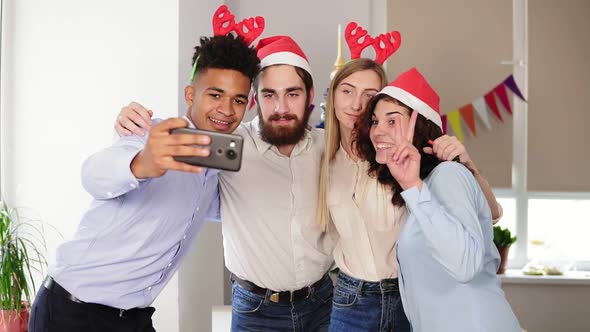Happy Business People in Santa Hats are Doing Selfie and Smiling While Celebrating New Year in the
