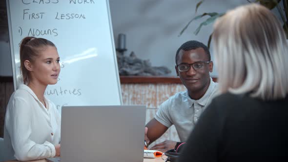 White Woman and Black Man Having an English Lesson and Talking with Their Woman Teacher