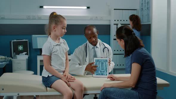 Doctor Explaining Radiography Results to Small Child and Mother