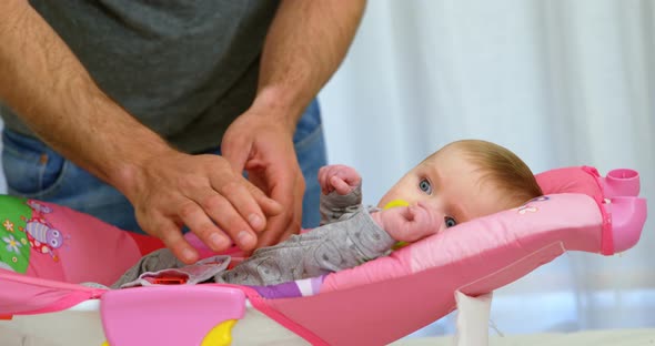 Father putting his baby to sleep on baby bed 