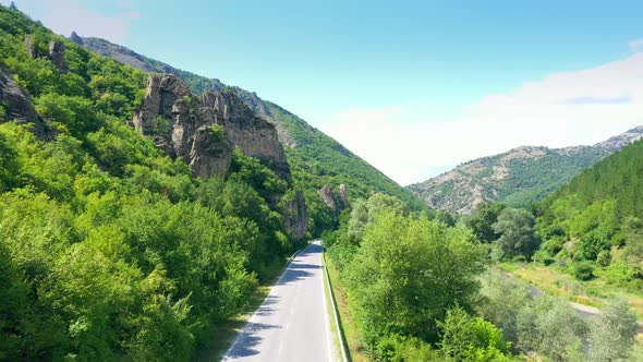 Aerial Drone View: Scenic Road In Mountain Range During A Vibrant Sunny Day