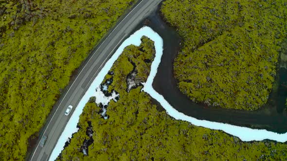 Aerial View Of White Car Driving In The Road Along The Icelandic Field In Reykjanes, Iceland.