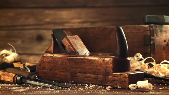 A Planer Falls on a Wooden Table with Sawdust