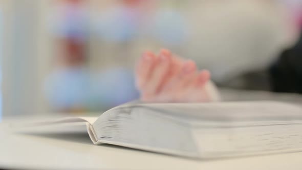 Female Hands Flipping Pages of Book Close Up