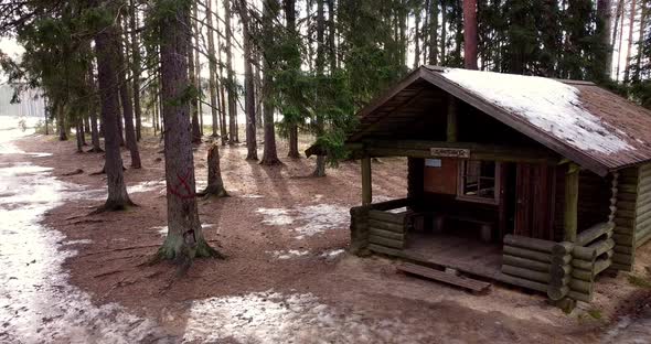 Flying Through Forest Overlooking Log Cabin Covered with Snow