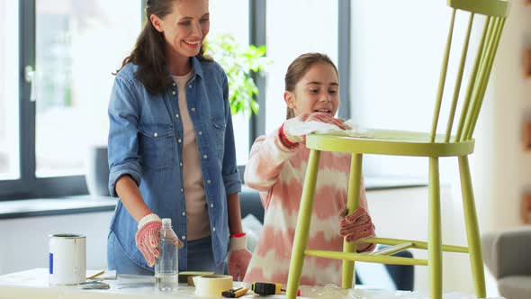 Mother and Daughter Cleaning Old Wooden Chair