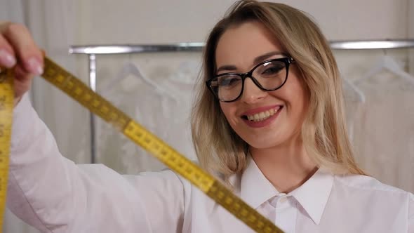 Closeup of a Woman Seamstress Holding a Measuring Tape in a Sewing Workshop