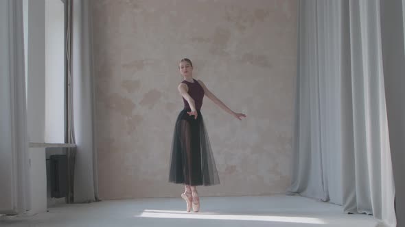 Young Ballerina in a Black Transparent Skirttraining in the Studio Loft Style Standing By the Window