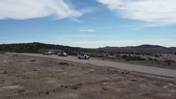 Drone footage of three cars parked on the desert road in Erongo region, Namibia