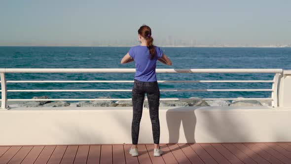 Girl Wearing Medical Mask and Does Exercises Near Sea 