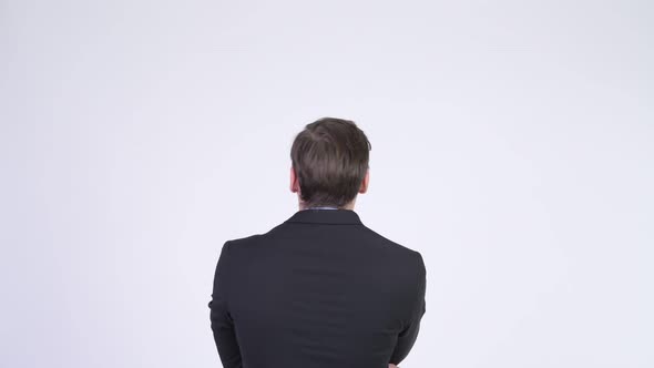 Rear View of Young Businessman Pointing Finger