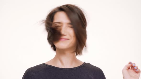 Portrait of Young Pretty Girl Looking in Mirror Correcting Hair and Smiling