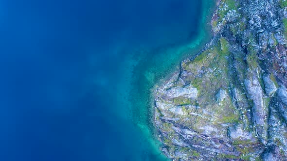 Blue Water at the foot hills of a rocky mountain, Aerial view