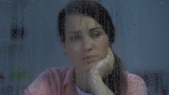 Depressed Pensive Middle-Aged Lady Looking in Rainy Window, Suffering Loneliness