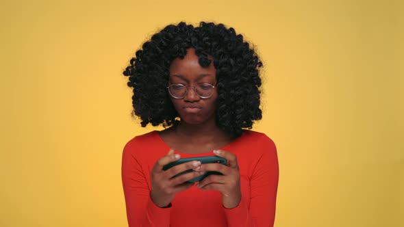 Pretty African Woman Playing Online Games on Smartphone