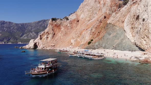 Drone Shooting of Tourists on a White Sandy Beach Surrounded By Volcanic Rocks of the Island of