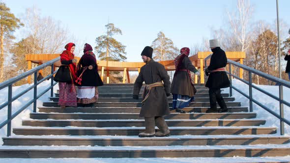 Russian Folk - Men and Women in Felt Boots Are Dancing on the Stairs in the Winter Park