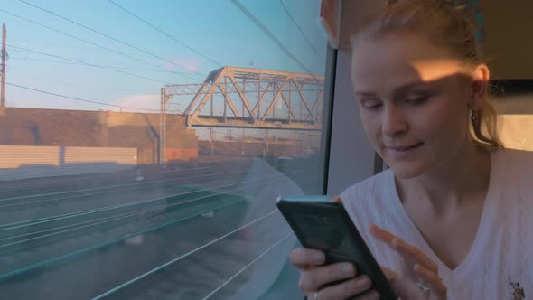 Young Woman Rides a Train and Looking Out the Window