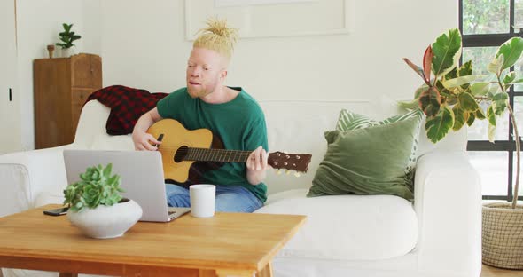 Albino african american man with dreadlocks playing guitars and singing